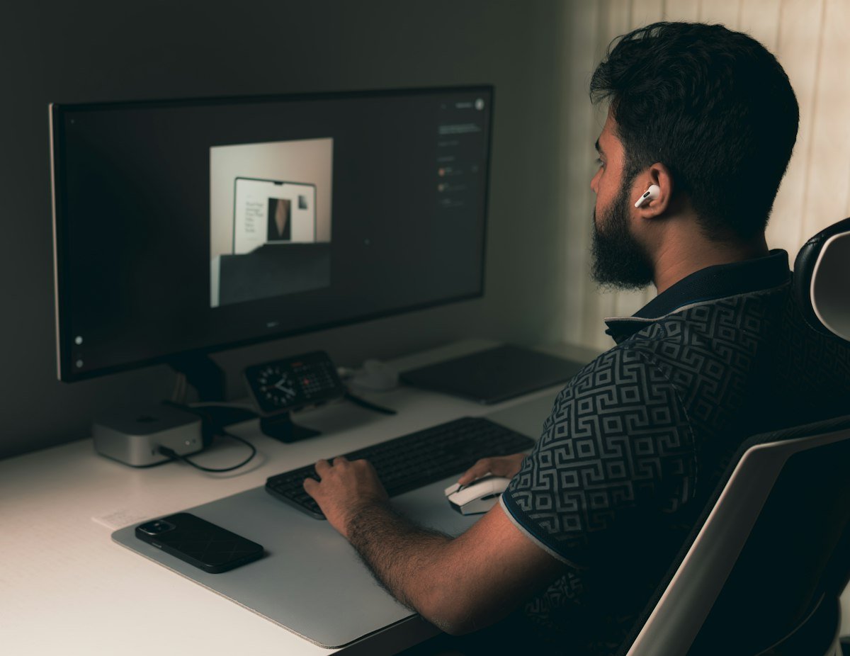 Persona trabajando frente a un ordenador con un tablero de diseño web
