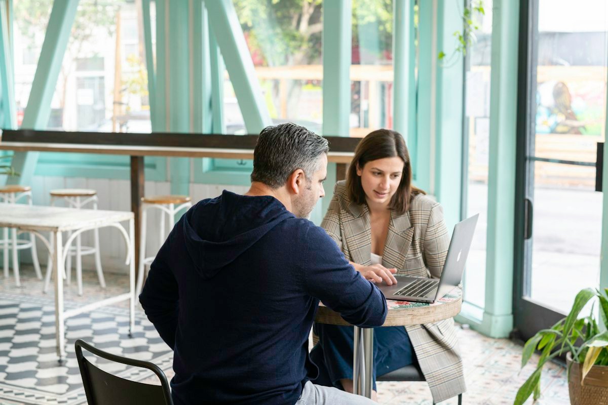 Reunión de trabajo con un portátil en la mesa de una cafetería